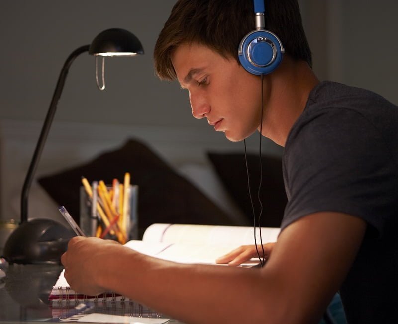 Teenage Boy Listening To Music Whilst Studying At P95RH64